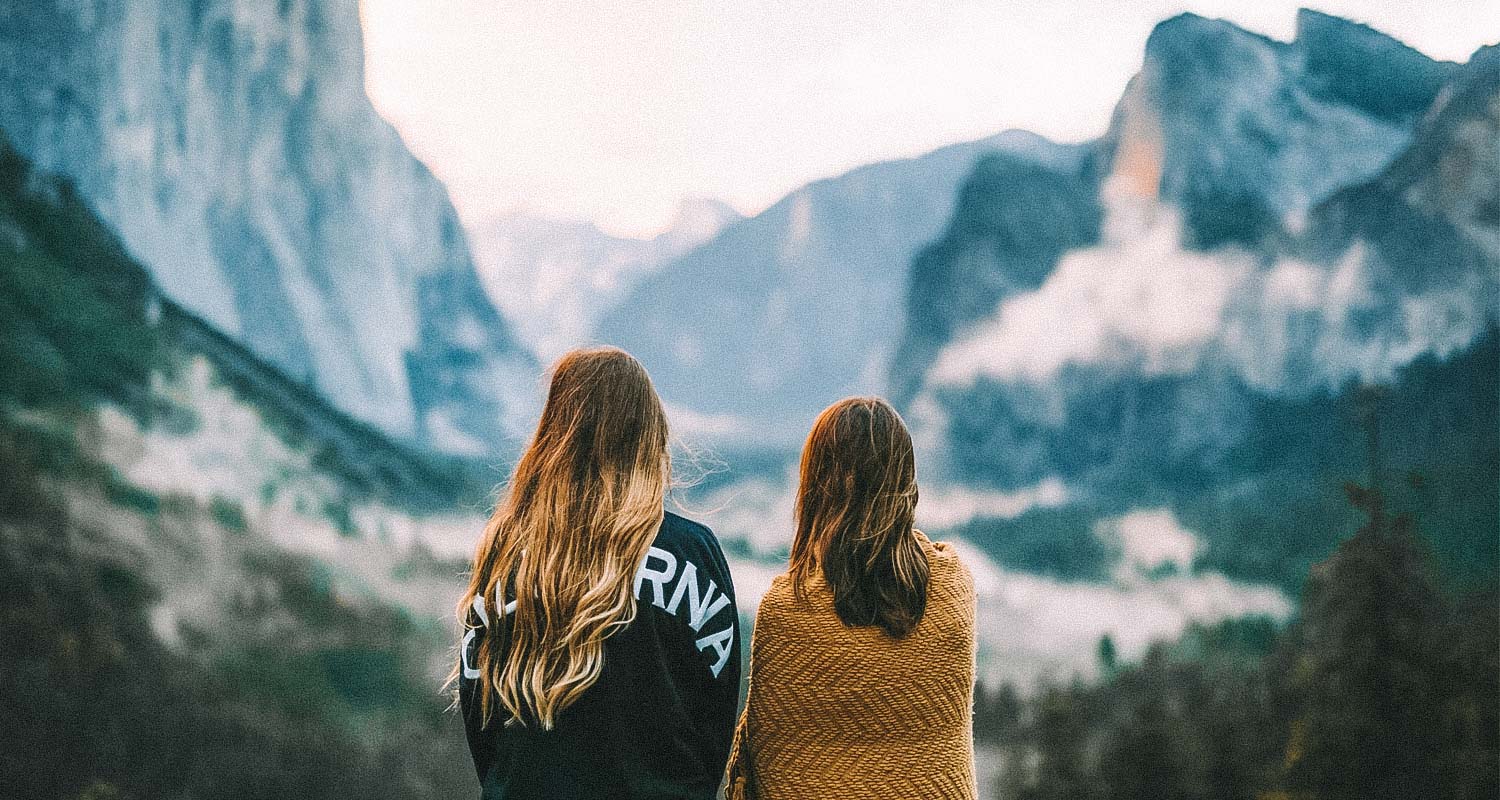 duas pessoas com montanhas ao fundo