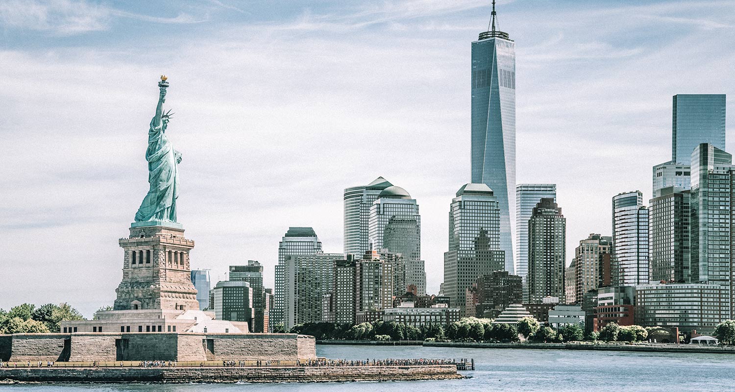 Estátua da Liberdade com edifícios ao fundo, em Nova York, maior metrópole americana