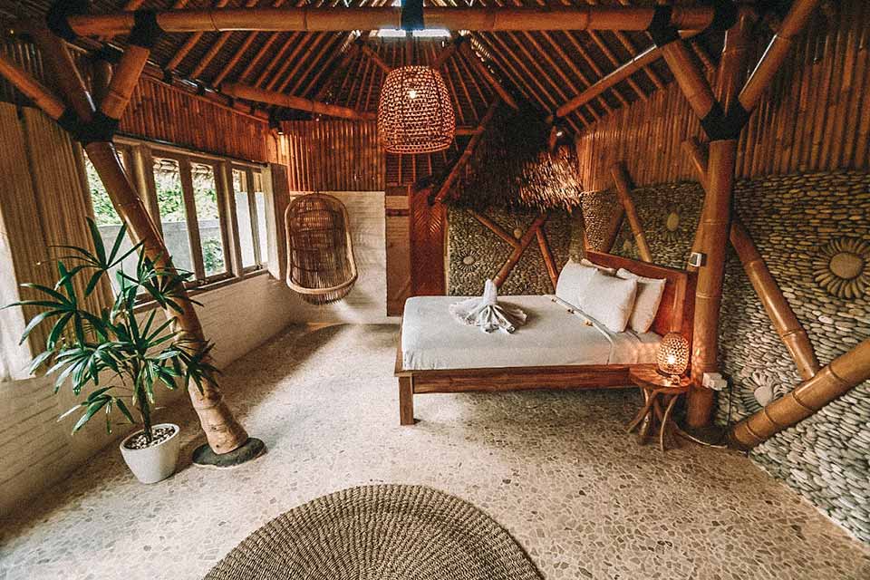 Quarto com cama de casal e decorações emm bambu