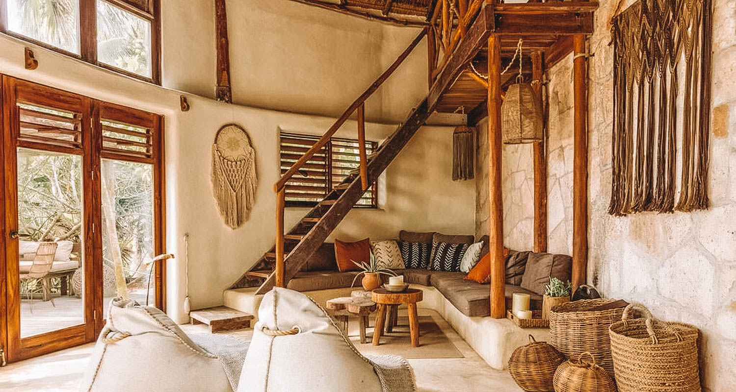Sala de estar com decoração em palha, janelas e escada em madeira