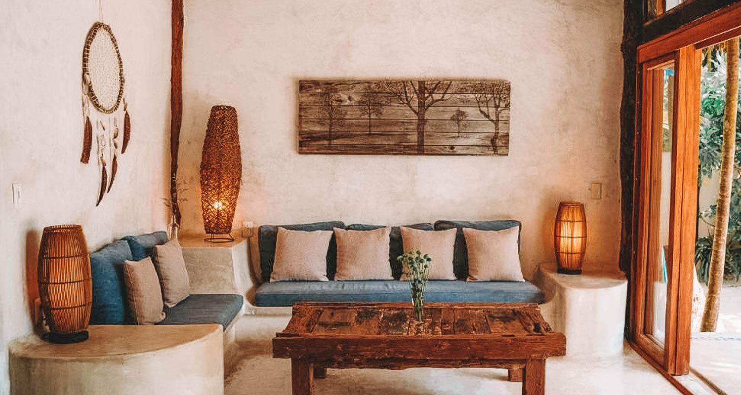 sala de estar com dois sofás azul, almofadas cinzas e mesa de centro de madeira
