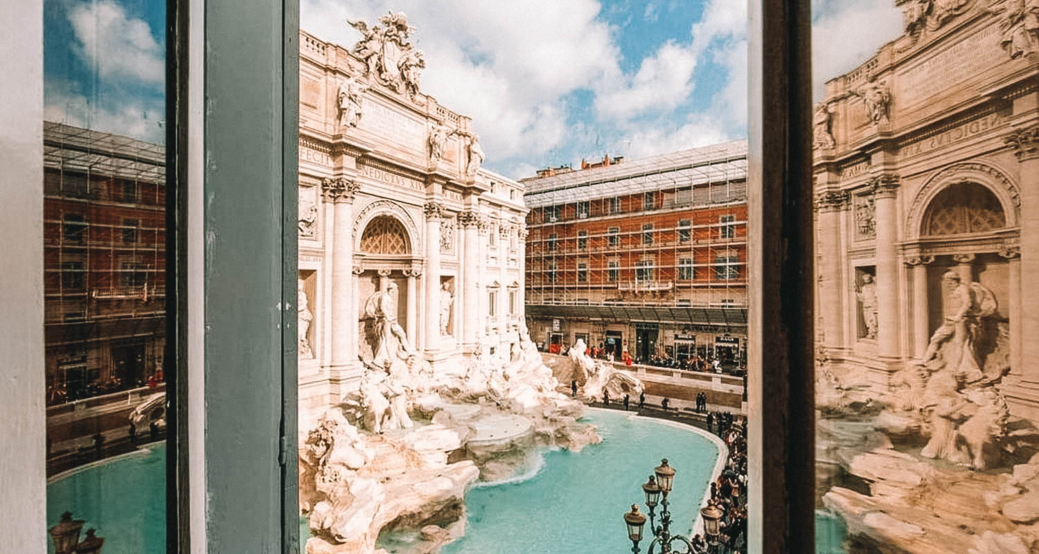 Janela aberta ao meio com vista para a Fontana di Trevi em Roma