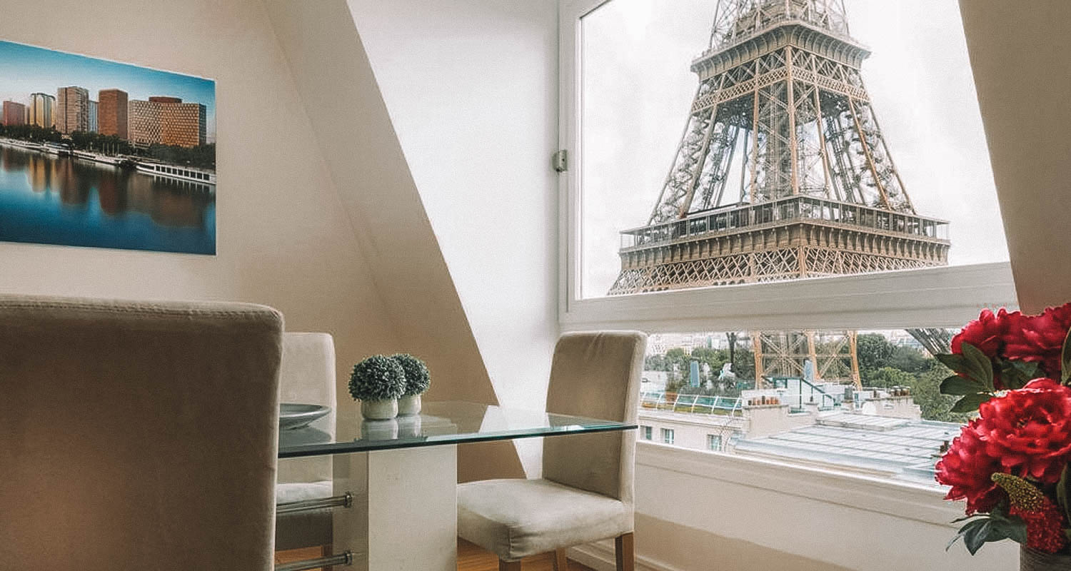 Sala de estar com janela com vista para a Torre Eiffel
