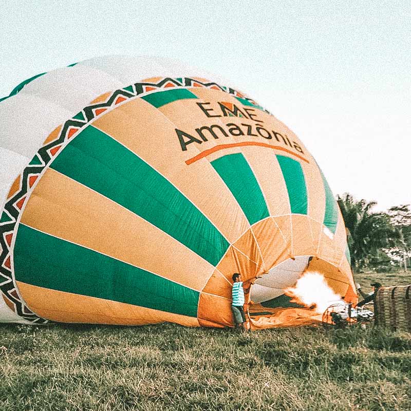 Balão verde e amarelo sendo montado na Floresta Amazônica. Passeios de balão no Brasil.