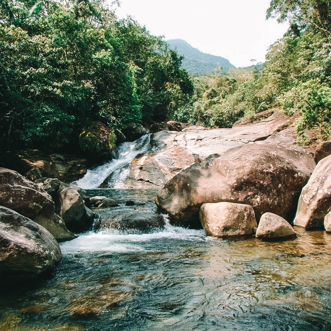 Água caindo em uma grande pedra e desembocando em um lago