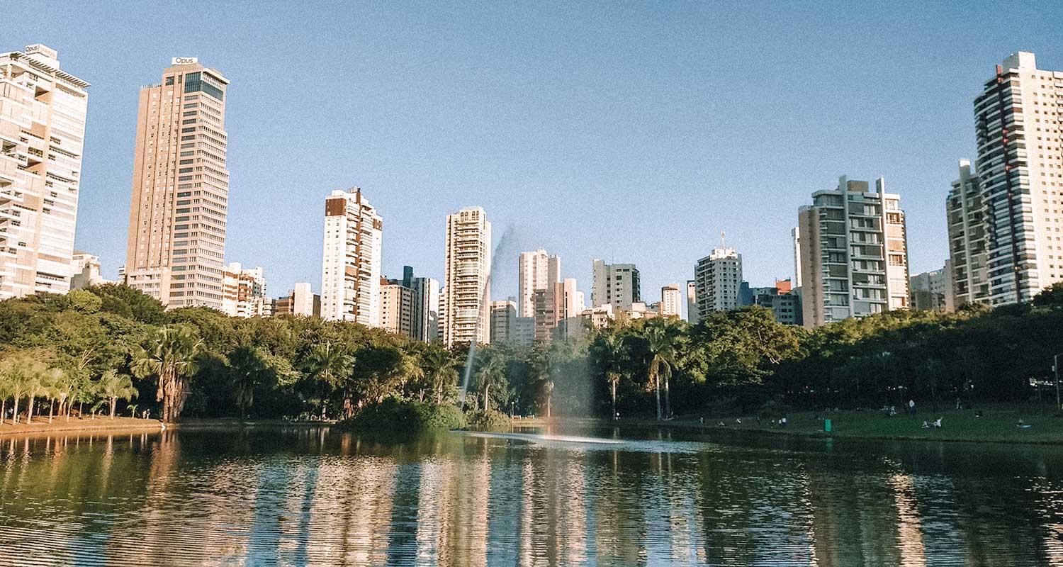 Parque com lago e prédios ao redor, no entardecer, em Goiânia, Goiás