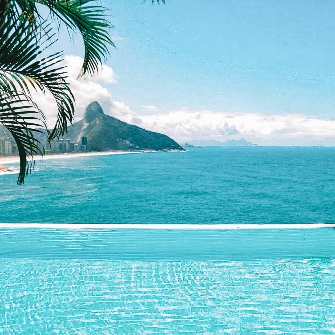 Piscina com borda infinita com vista para o mar e um morro no Rio de Janeiro