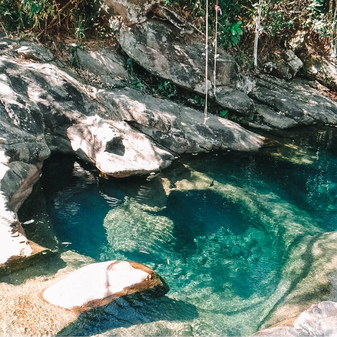 Poço em meio as pedras com coloração azul-esmeralda