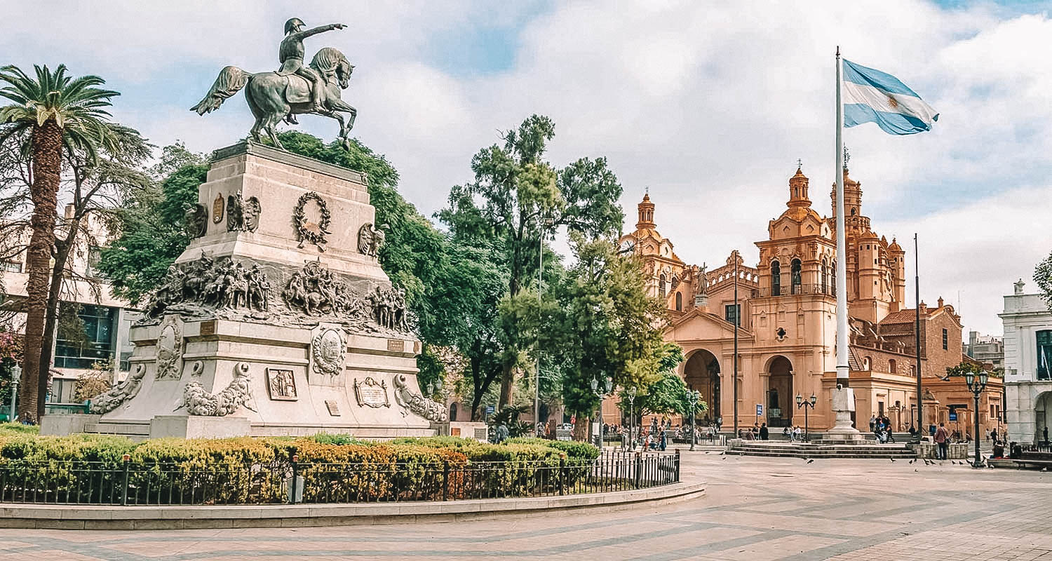 Praça em frente a casa rosada com estatua ao meio