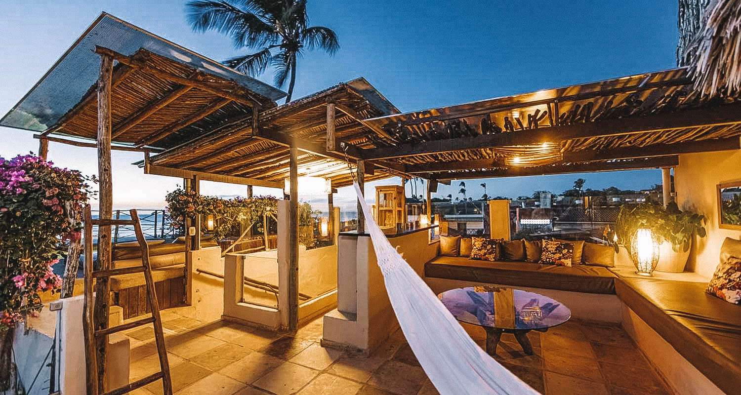 Terraço do hotel ao entardecer com rede branca