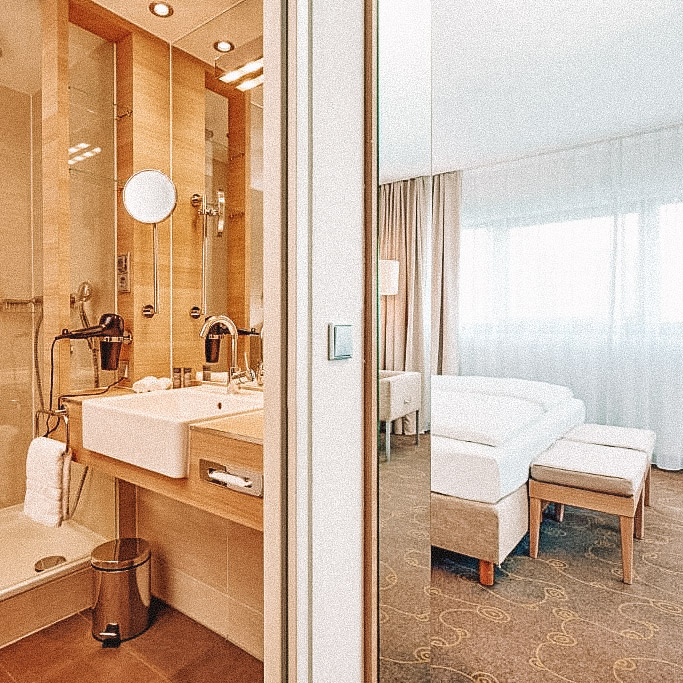 Quarto e banheiro do H+Hotel Salzburg