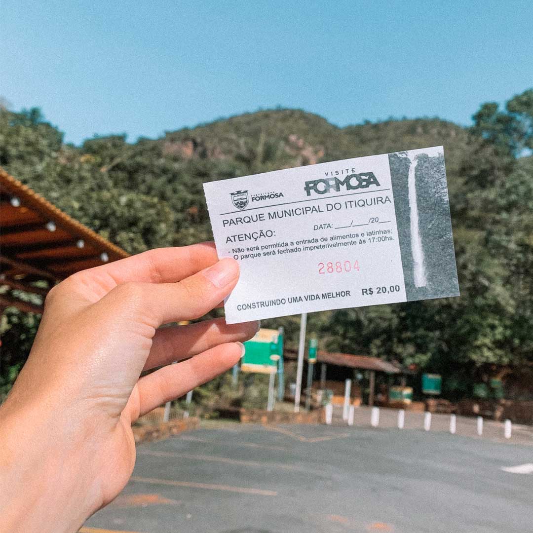 Mão segurando o ingresso do Salto do Itiquira