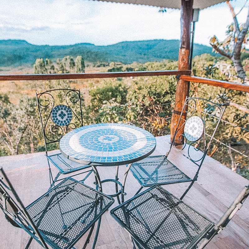 Mesinha em varanda com vista para a Chapada dos Veadeiros. Hotéis e pousadas em Goiás.