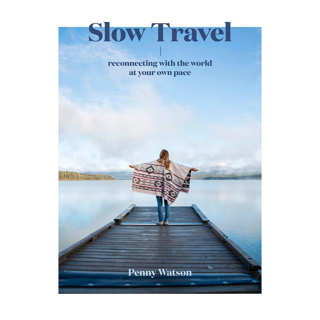 Capa do livro Slow Travel com uma mulher de braços abertos olhando em direção ao lago