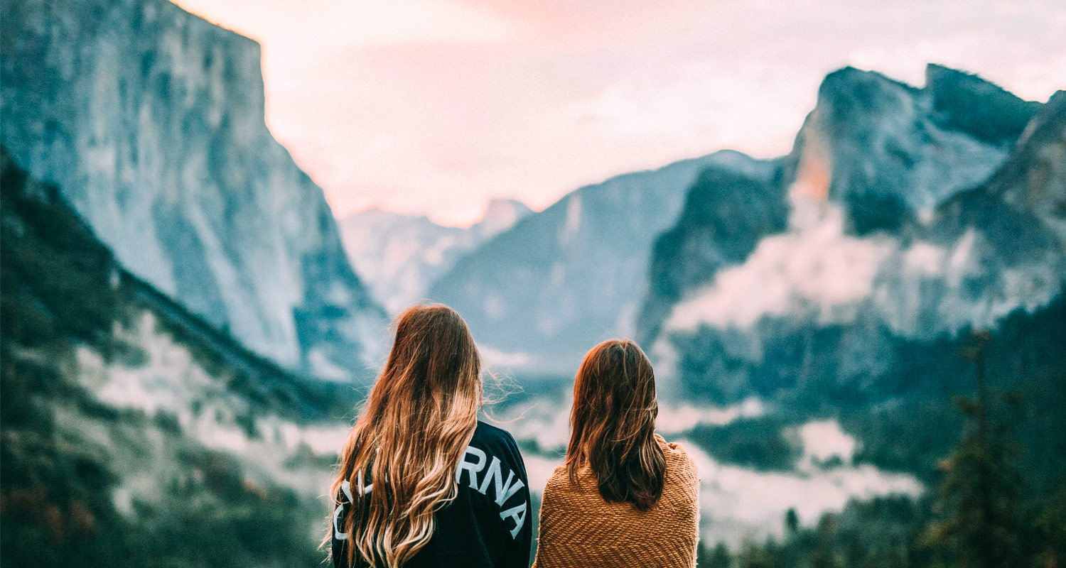 Duas mulheres de costas olhando a paisagem da montanha
