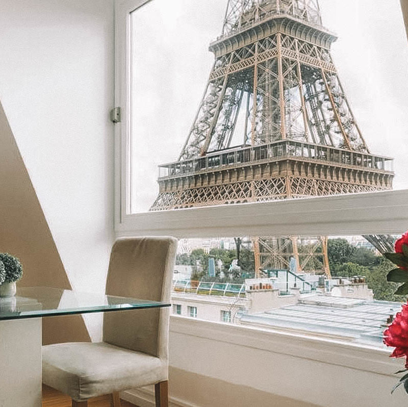 Sala de estar com janela com vista para a Torre Eiffel